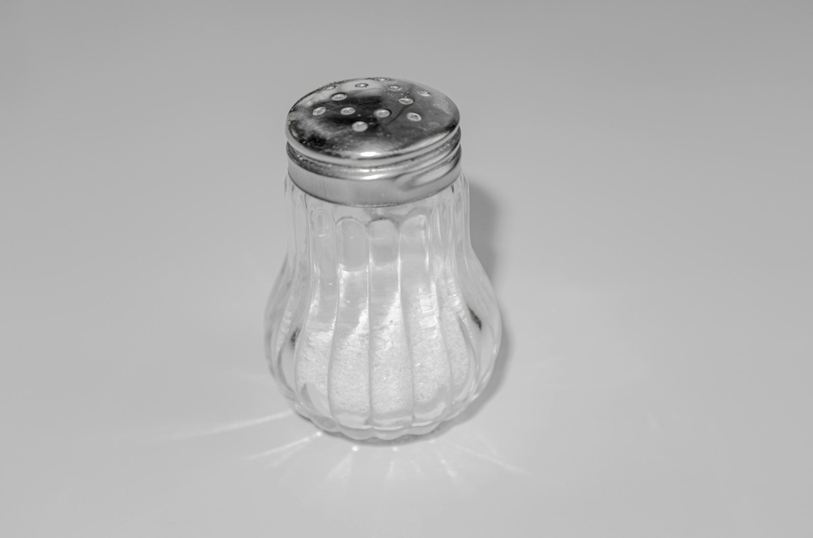 a glass salt shaker on a white table